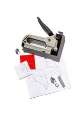 Silver furniture stapler gun with staples and the drawing of the armchair isolated on white...