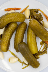 Pickled cucumbers on a white background. Close-up of pickled cucumbers in a ceramic plate. close up. Top view
