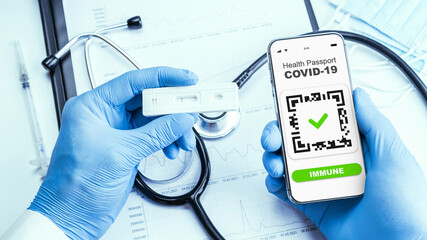 Covid passport doctor holding. Coronavirus vaccination certificate of immunity passport on smartphone screen with doctor stethoscope, syringe and medical equipment on hospital white background.