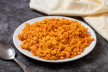 Bulgur pilaf on a dark background. Close-up of Turkish food Bulgur Pilav in a ceramic plate