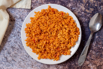 Bulgur pilaf on a dark background. Close-up of Turkish food Bulgur Pilav in a ceramic plate. Top view