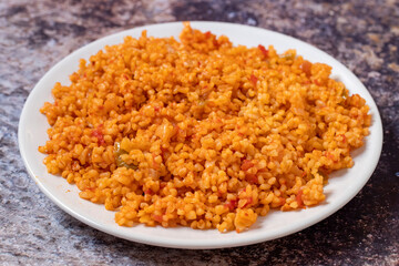 Bulgur pilaf on a dark background. Close-up of Turkish food Bulgur Pilav in a ceramic plate