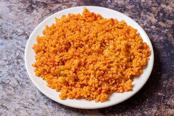 Bulgur pilaf on a dark background. Close-up of Turkish food Bulgur Pilav in a ceramic plate