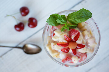 Fresh fruit salad with Greek yogurt in a glass glass. Vegetarian dessert.