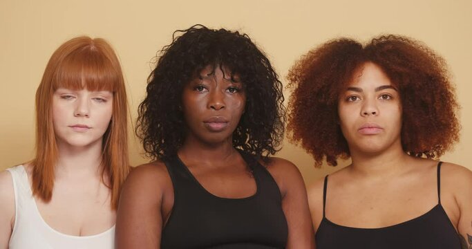 Multiraciial group of women friend posiing on beige background
