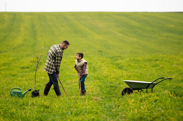 The young man and his son have fun in the field