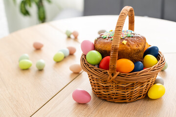 Easter cake with sprinkles, painted eggs and flowers on wooden table, flat lay. Space for text
