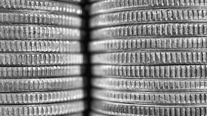 Stacks of US American coins of 25 cents quarters closeup. Black and white background or wallpaper...