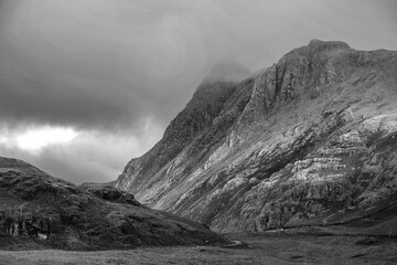 Black and white Stunning landscape of dramatic sunrise light over Blea Tarn in Lake District with stunning light