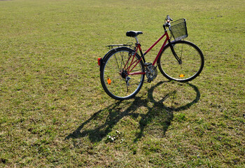 Fototapeta premium Red bike with basket on green grass