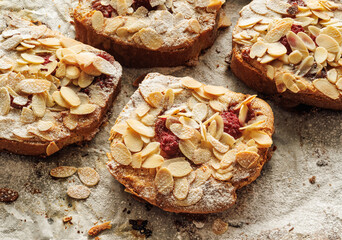 Bostocks with the addition of almond cream (frangipane) and raspberries made of baked brioche slices, close up view. Traditional french sweet toast. 