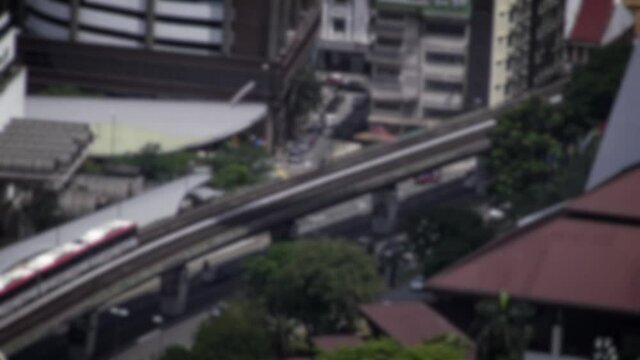 Defocused shot of elevated view of train moving to station at Kuala Lumpur city in exterior day. Aerial view of metro in Malaysia. Subway city commute. Traveling in Asia.