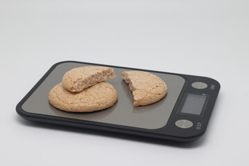 Nut cookies on electronic kitchen scales, accurate calorie counting, proper nutrition.