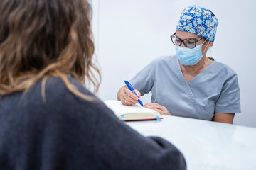 Woman assistant citing patient in the clinic