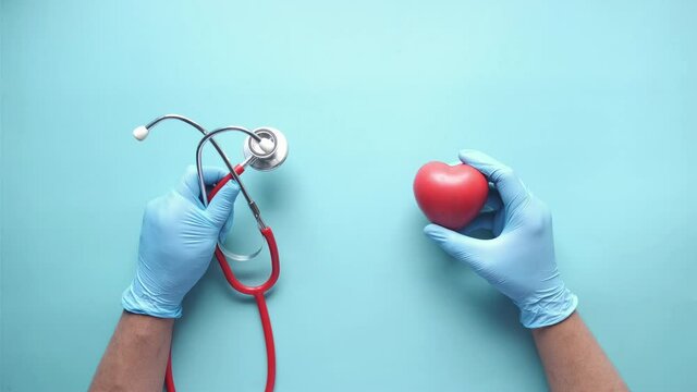 top view of doctor hand using stethoscope and hear shape symbol 