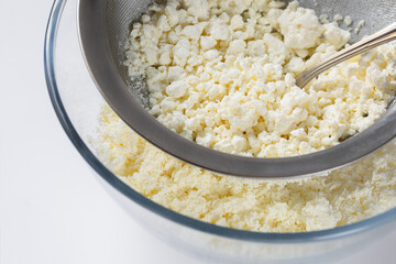Rubbing cottage cheese through a sieve. manual way.
