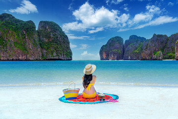 Young woman in bikini relax on the beach.Woman relaxing on white sand on Phi phi island, Thailand. - obrazy, fototapety, plakaty