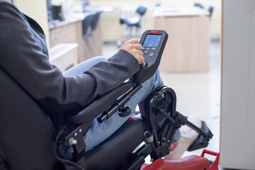 Close-up of a female hand on the control handle of an electric wheelchair