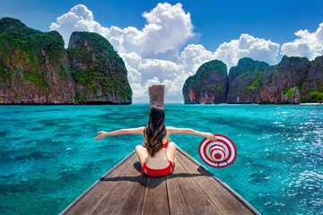 Beautiful girl in red bikini on boat at Koh Phi phi island, Thailand.
