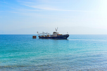 Vintage ship over Dead Sea landscape, Israel. The Dead Sea surface and shores. Bizarre salt deposits along the western coast of the Dead Sea on the background of abandoned ship.