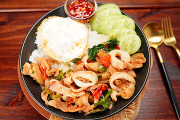 Fototapeta na wymiar Stir-fried squid with basil and fried egg with cooked rice Popular Thai food