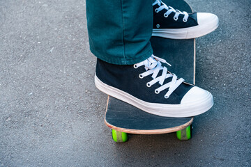 Legs of a man on a skateboard on the street