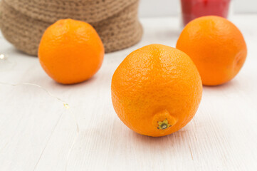 Fragrant tangerines in a knitted jute basket on a wooden table.