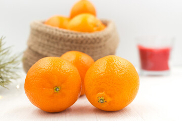 Fragrant tangerines in a knitted jute basket on a wooden table.