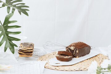 Chocolate marble loaf cake with chocolate glaze. On white cafe table.