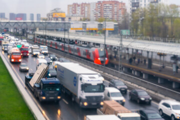 Defocus, blur, panoramic view of the dense traffic of cars along the Third Transport Ring, the arriving train at the Avtozavodskaya station Moscow Central Ring and residential buildings.