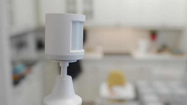 Smart home wireless motion sensor installed in the living room detects movement, motion detector used to detect burglar intrusion. High quality 4k footage