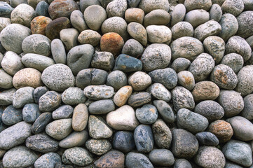 Background of stones. A wall of multicolored stones. Old masonry. An old wall of large stones.