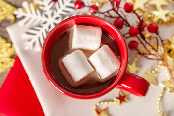 Hot chocolate in a red mug and golden decorations