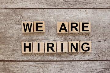 WE'RE HIRING CONCEPT. text on wooden blocks on a wooden background