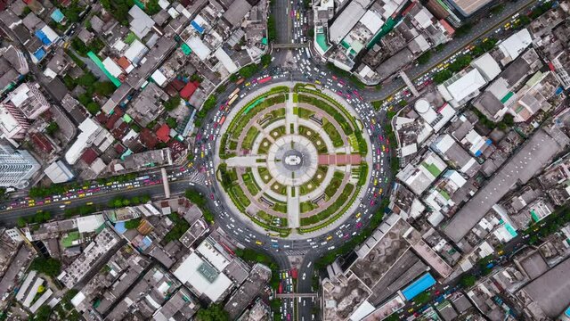 Top down aerial hyper lapse view of traffic around huge roundabout during rush hour in Bangkok, Thailand. 