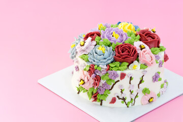 Fototapeta na wymiar Homemade cake decorated with beautiful flowers on pink background,