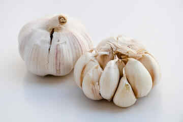 Two bulbs of garlic on a white background.