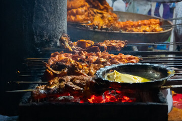 Spicy chicken seekh kababs are being grilled with charcoal in barbeque with metal skewers,at evening for sale as street food in Old Delhi market. It is famous for spicy non vegetarian street foods.