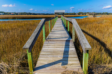 Fototapeta premium Long Wooden Bridge Over The Salt Marsh of The Waccamaw River, Pawleys Island, South Carolina, USA