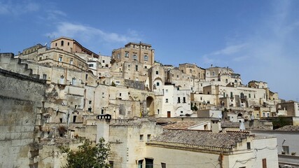 Fototapeta na wymiar ITALY-Matera is a city located on a rocky outcrop in Basilicata, in Southern Italy. It includes the Sassi area, a complex of Cave Houses carved into the mountain