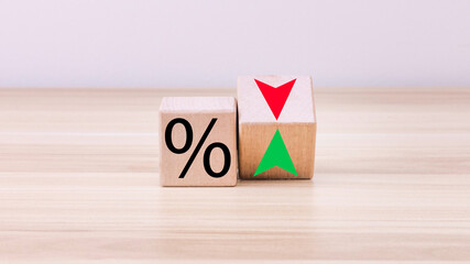 Wooden cubes change the direction of an arrow to symbolize that the interest rates are going down or vice versa. Business concept. Copy space, beautiful white background.