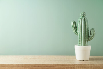 Leeres Holzregal mit Kaktus auf grünem Hintergrund. Küchenmodell für Design