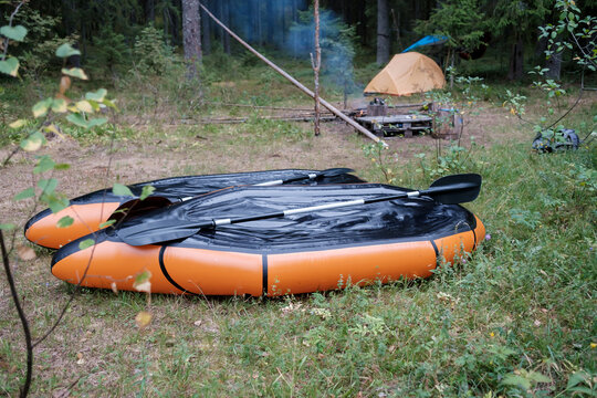 Two packrafts lie to dry in the camp, against the backdrop of a tent, in the forest, in summer. Active lifestyle concept.
