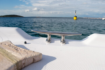 Marine detail with steel mooring cleat on the small plastic pleasure boat, Adriatic sea, Croatia
