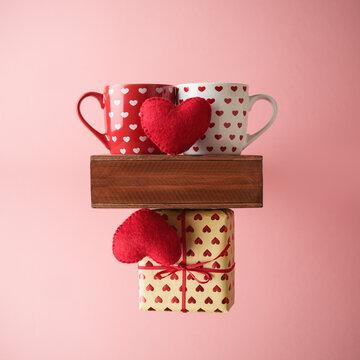 Valentines day creative concept with coffee cup, heart shape and gift box over pink background