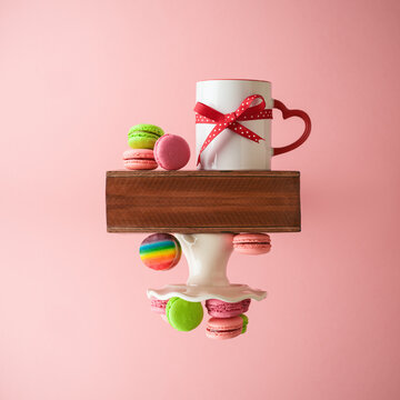 Valentines day creative concept with coffee cup and macaroons dessert over pink background