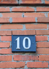 Fototapeta na wymiar Targa con numero 10 su sfondo di mattoni
