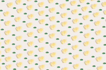 Sunlight summer pattern made with a yellow lemon slice and green leaves on a bright light background. Minimal summer concept.