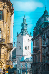 view of lviv street with cathedral church tower between buildings