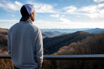 man with hat on the top of a mountain